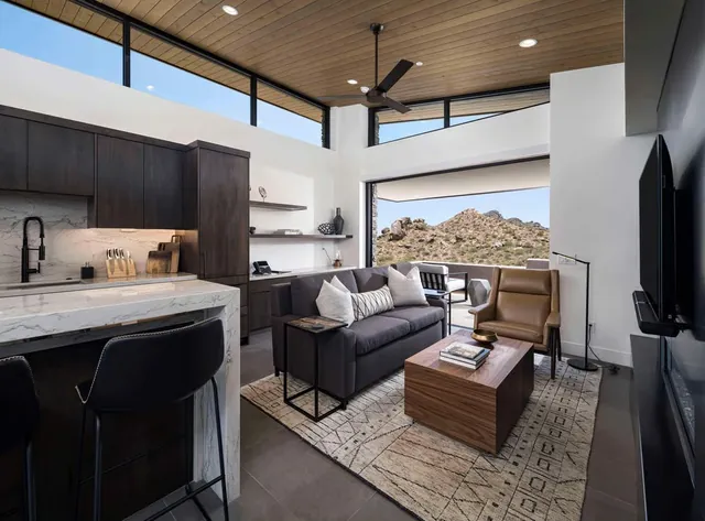 Great room with a linear fireplace, sofa and leather chairs