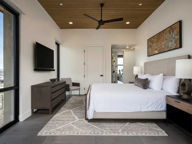 King bedroom with a white oak ceiling and desert art