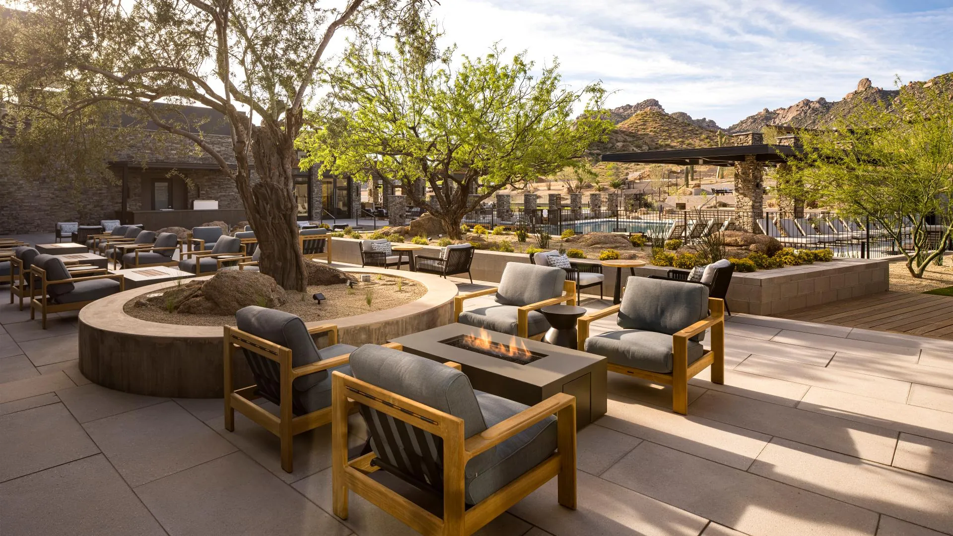 Fire pit lounge with teak chairs under palo verde trees