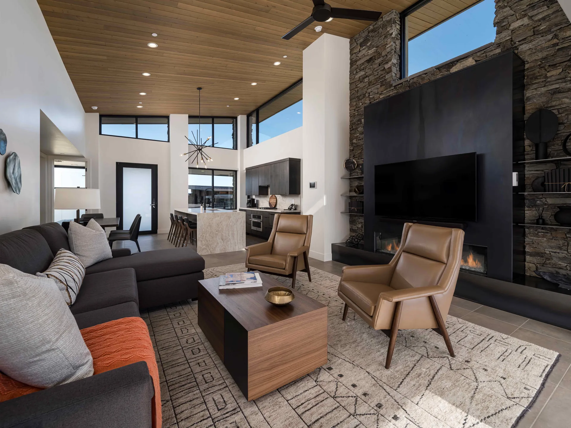 A casita great room with a black steel fireplace wall, clerestory windows and a white oak ceiling