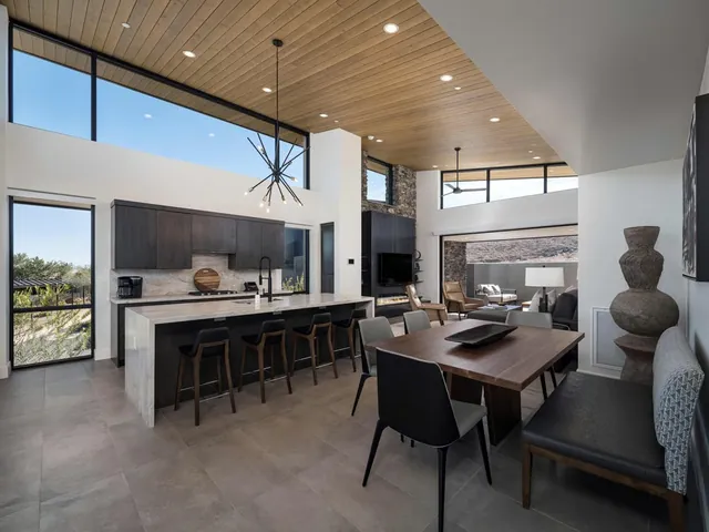 Kitchen island with bar stools and the dining table beyond